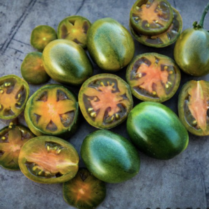 Green and orange tomatoes sliced open on a surface.